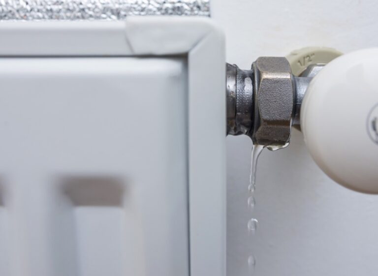 Leaking heating radiator. Defective heater. The need for plumbing work in the heating period at home. Selective focus.
